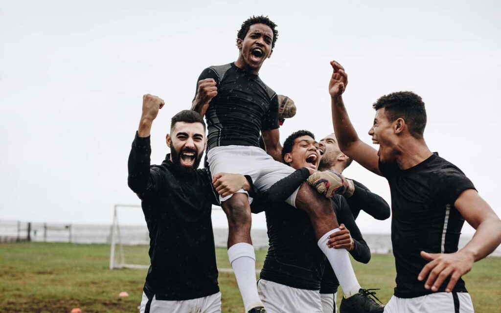 Fünf Fußballspieler beim jubeln