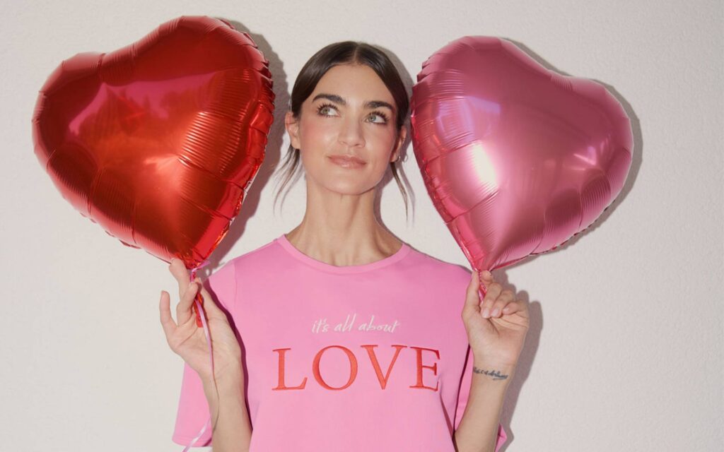 Frau im pinken T-Shirt und Herzchen Luftballons