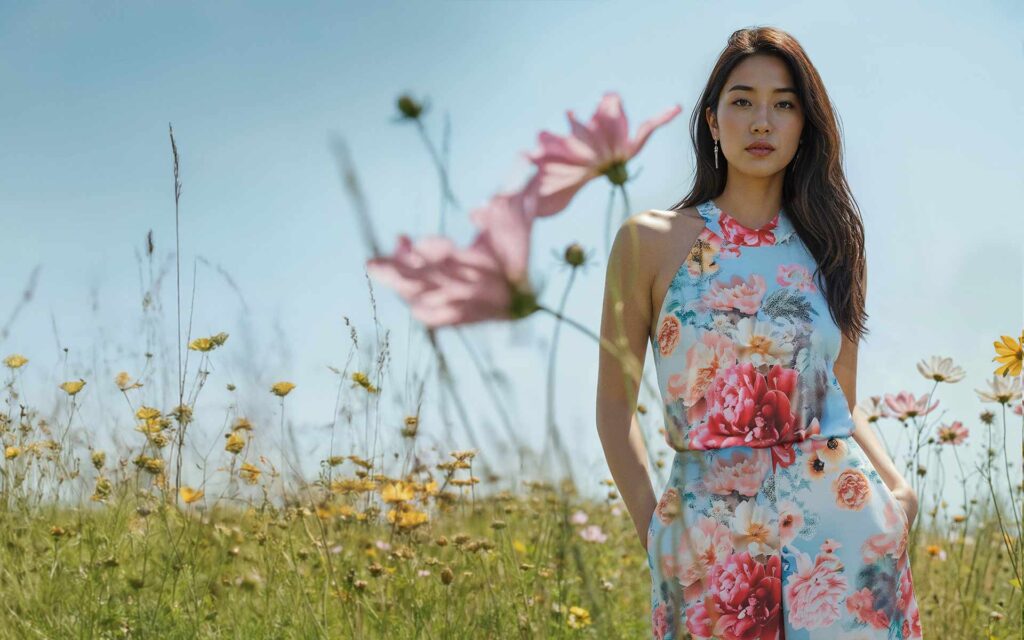 Frau im geblümten Kleid im Blumenefeld