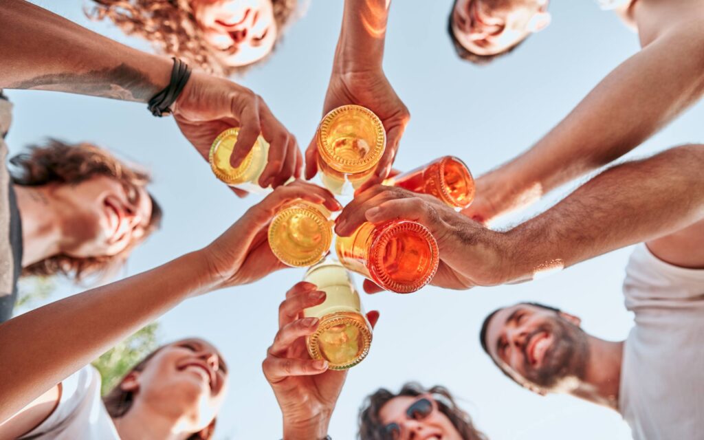 Menschen stoßen im Sommer gemeinsam an