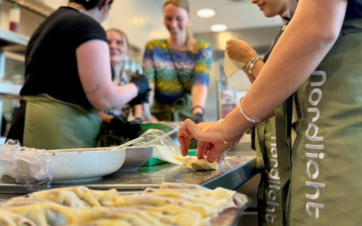 Mehrere Personen beim kochen in nordlicht Schürze