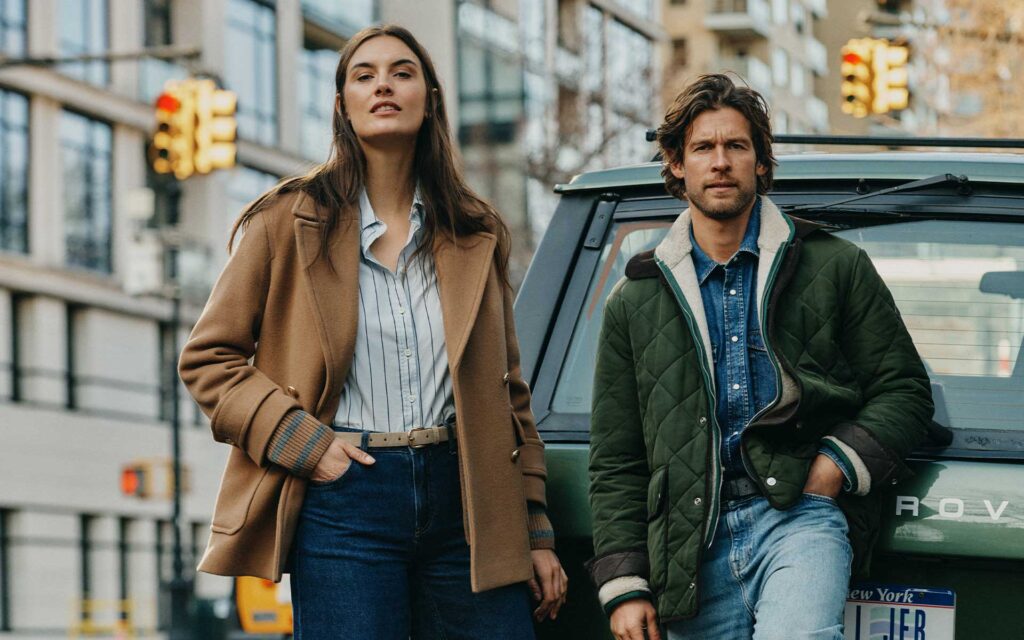 Frau und Mann vor einem Range Rover in stylischer Herbst-Bekleidung