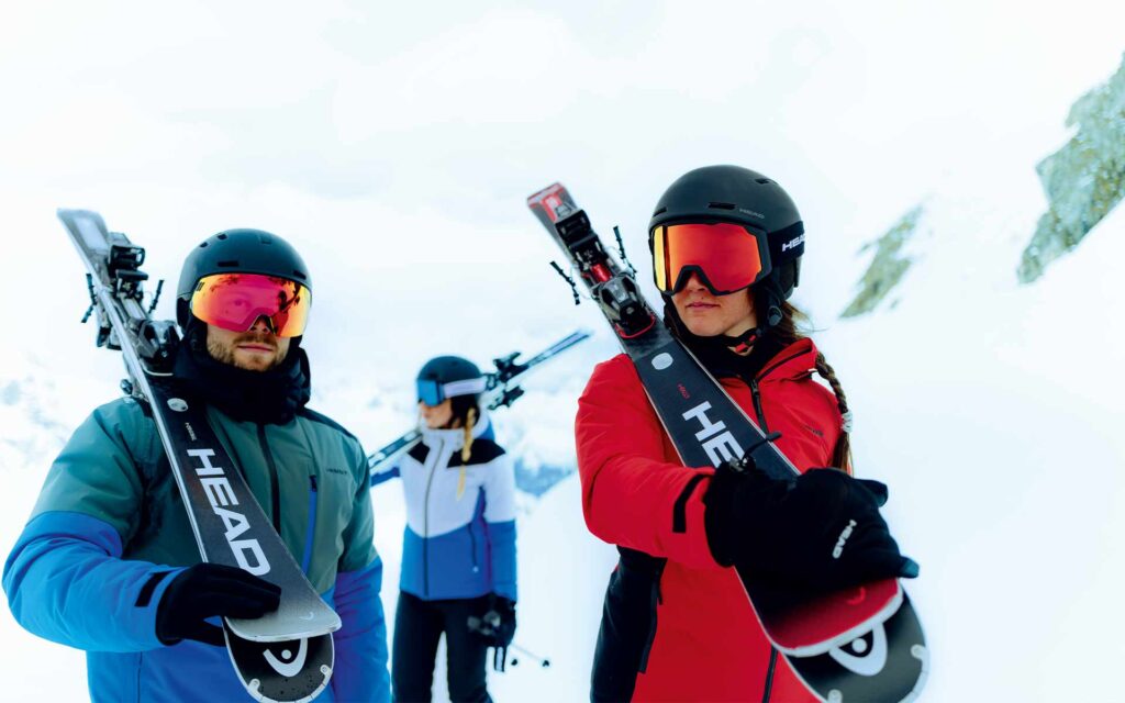 3 Skifahrer mit Skiern in der Hand