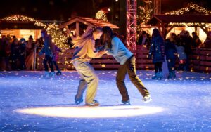 Zwei Mädchen auf der Eislaufbahn drehen sich im Kreis