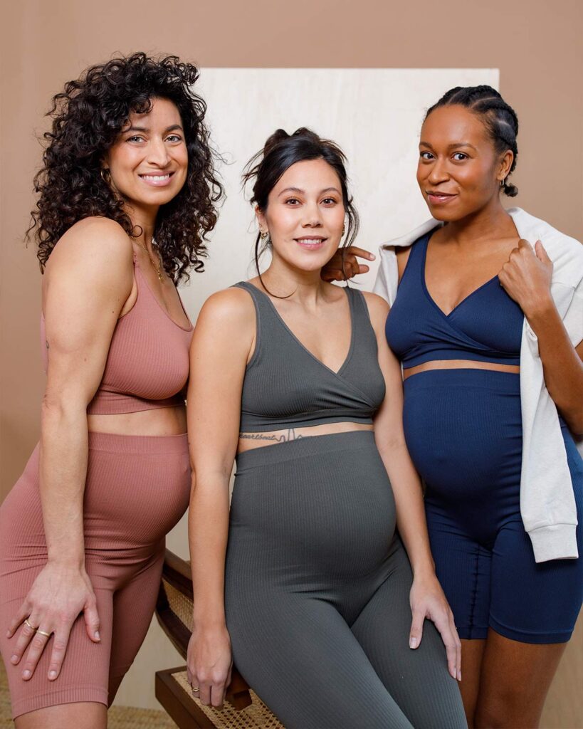 Drei schwangere Frauen in enganliegenden Outfits