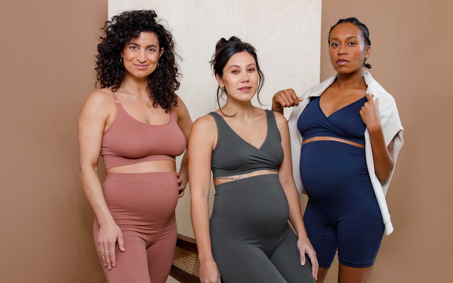 Drei schwangere Frauen in enganliegenden Outfits