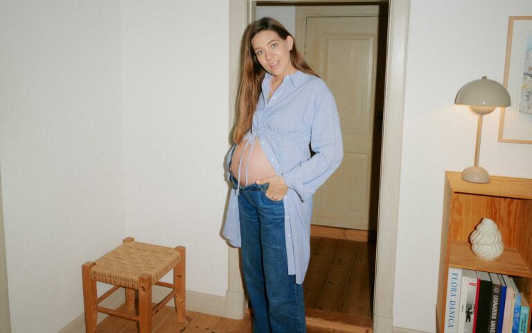 Schwangere Frau in Jeans und langem Hemd