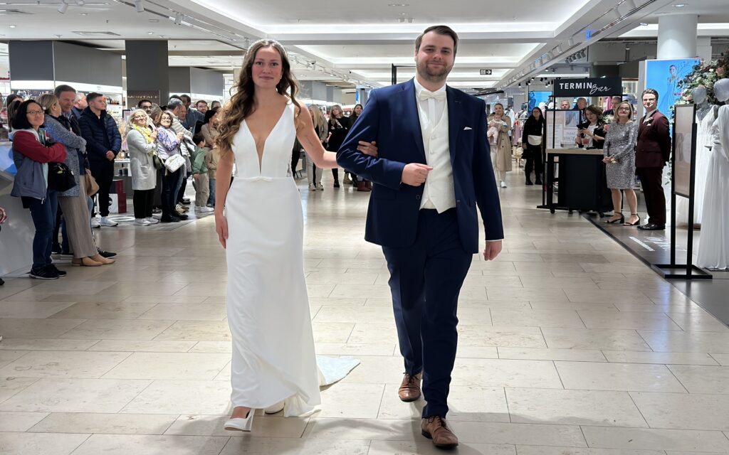 Frau in Brautkleid und Mann in Smoking auf dem Laufsteg