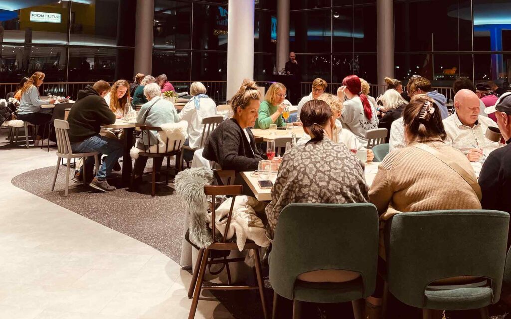 Menschen an Tischen im norldicht Retsaurant beim gemeinsamen Bingo spielen