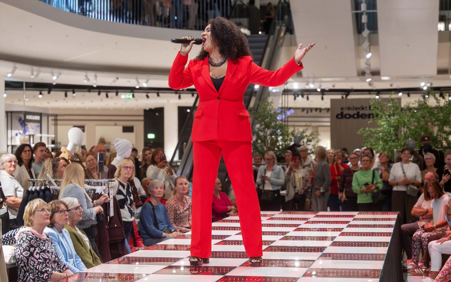 Sängerin im roten Anzug performt auf der Bühne