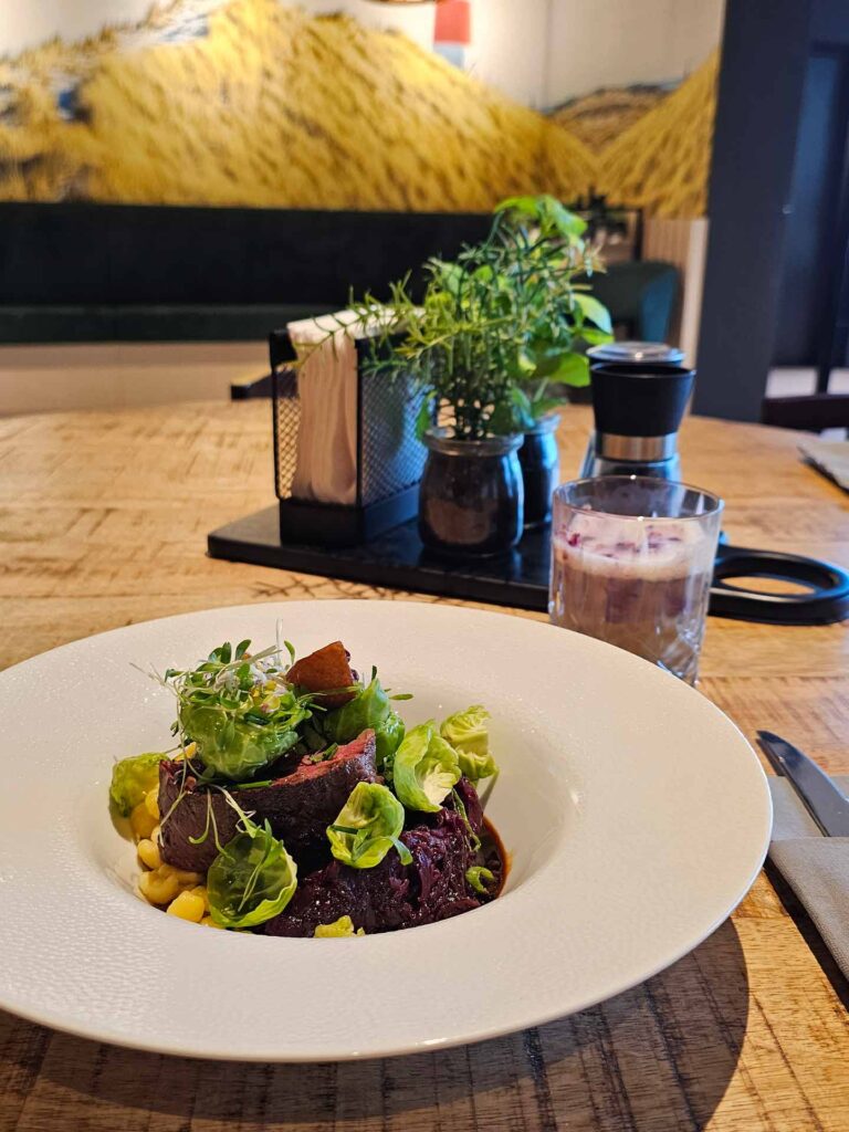 Hirschrückensteak/ Knöpfle/ Rotkohl/ Rosenkohlbätter auf einem Teller