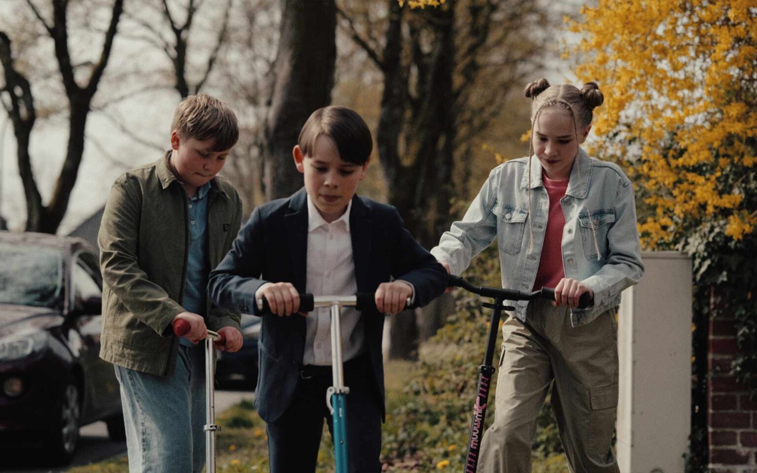 Drei Kinder auf Rollern