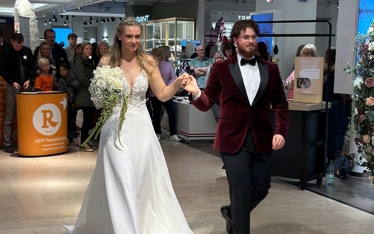 Frau in Brautkleid und Mann in Smoking auf dem Laufsteg