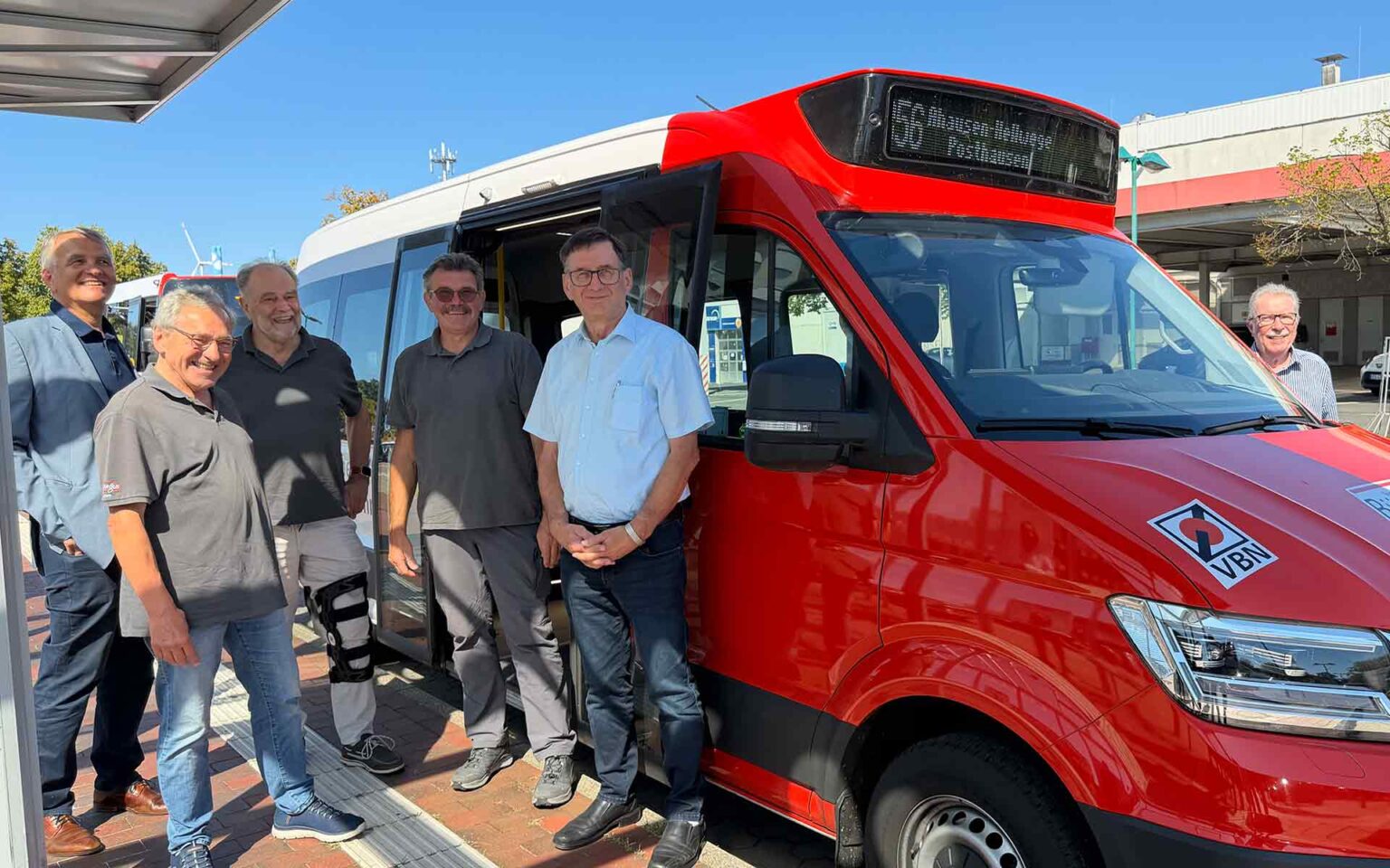 Roter Bus mit Personen davor