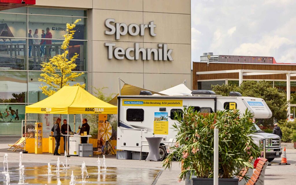 Wohnmobil und gelber Pavillion vor der Sport und TechnikWelt