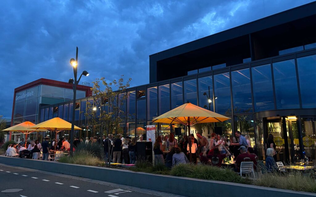 Die ROOTS Foodhall von außen in der Dämmerung
