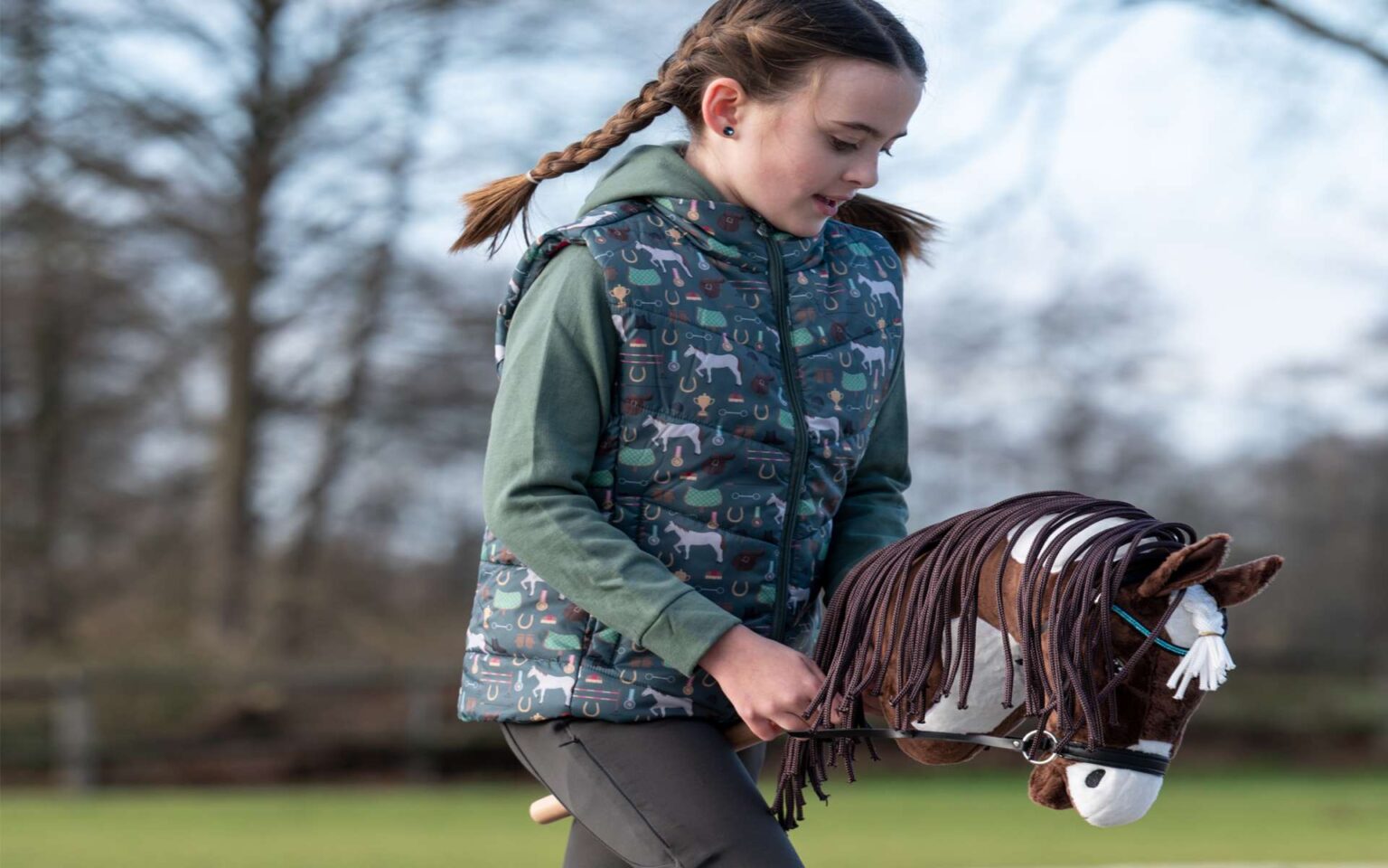 Kleines Mädchen macht draußen Hobby Horsing
