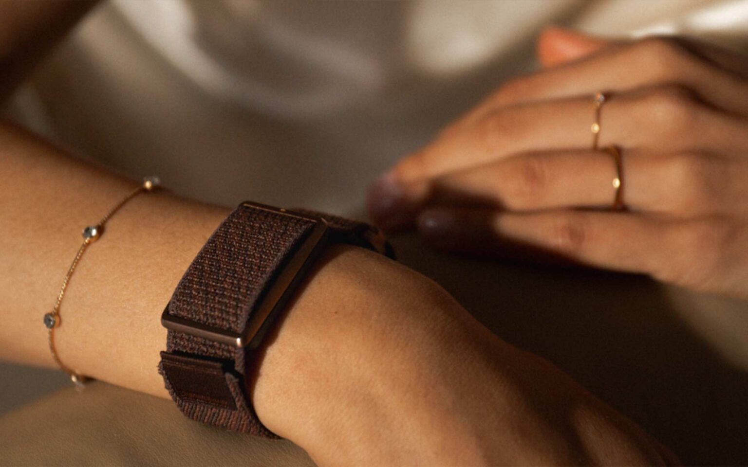 Arm mit Loop Armband und goldenem Schmuck