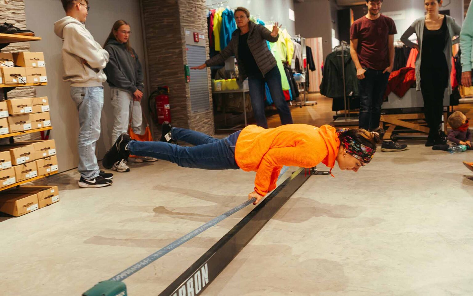 Frau balanciert mit den Händen auf einer Slackline