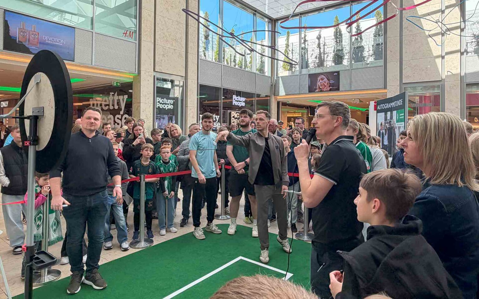 Viele Menschen schauen auf einen Dartsaufbau