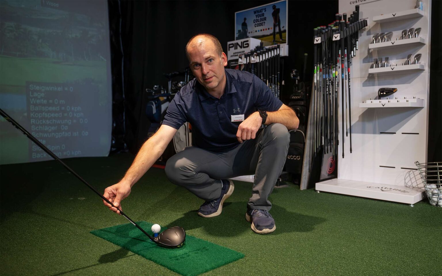 Mitarbeiter beim Golf im Golfsimulator in der Sportwelt