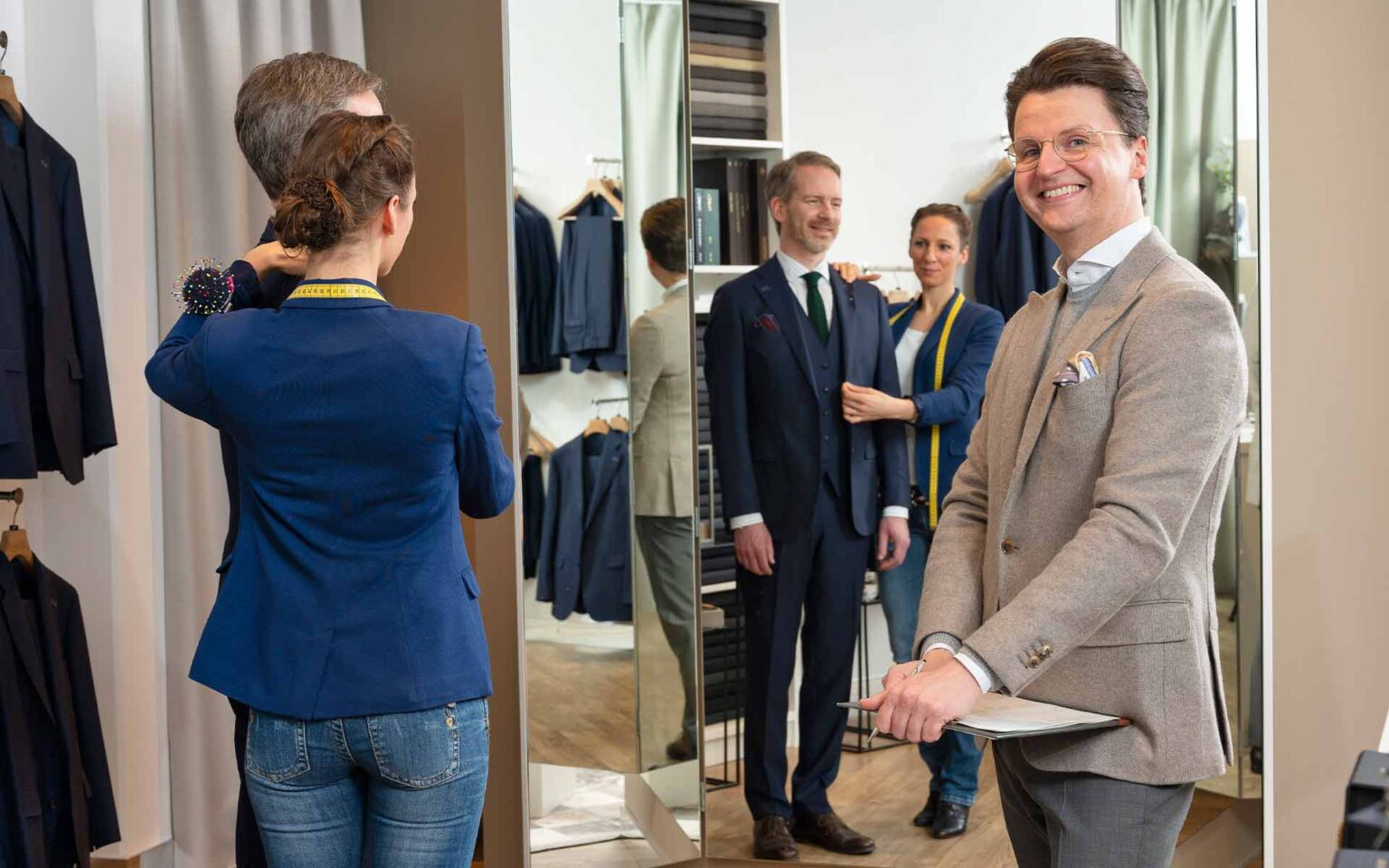 Mann mit zwei Beratern in der Maßkonfektion