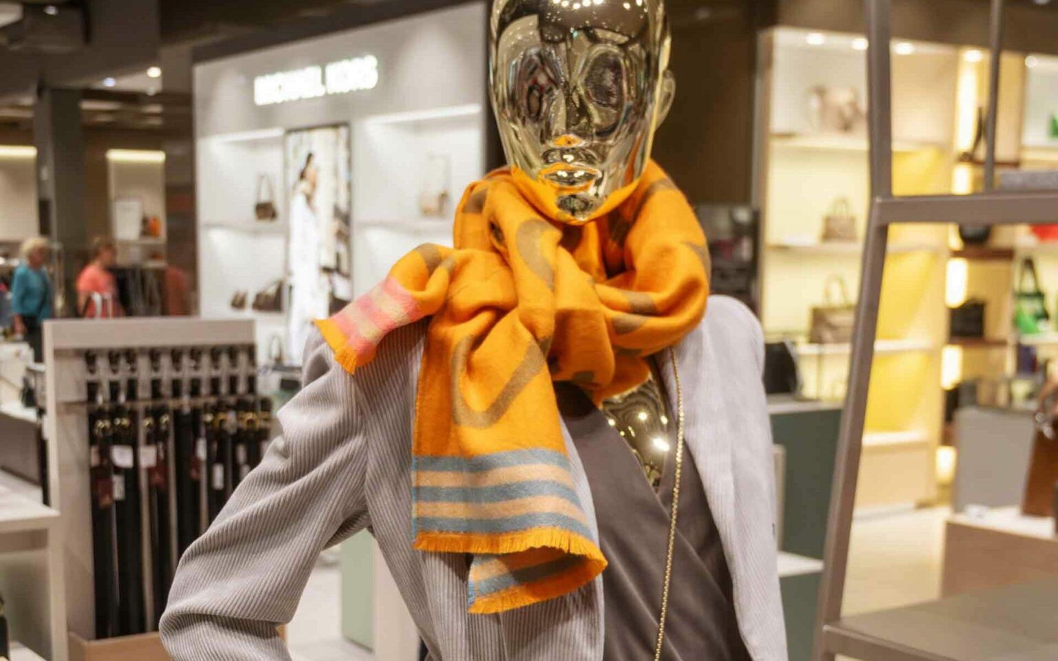 Damenfigur mit grauem Blazer und orangenem Schal
