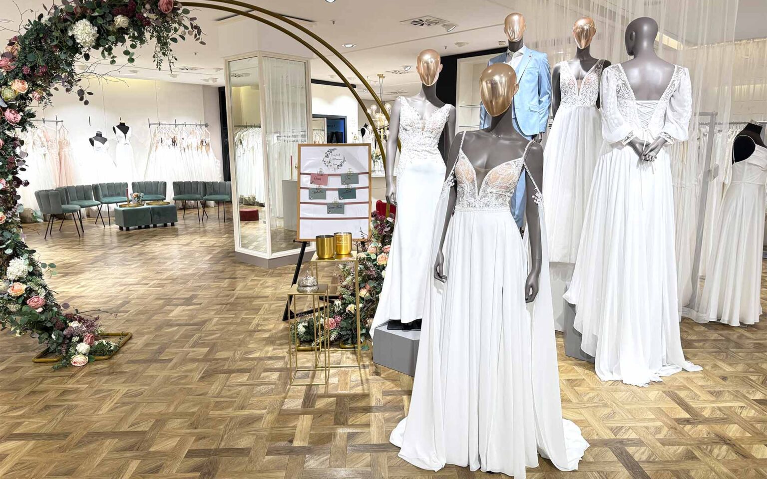 Eingangsbereich des Brautsalons mit 4 Figuren in Brautkleidern und eine Figur im Anzug