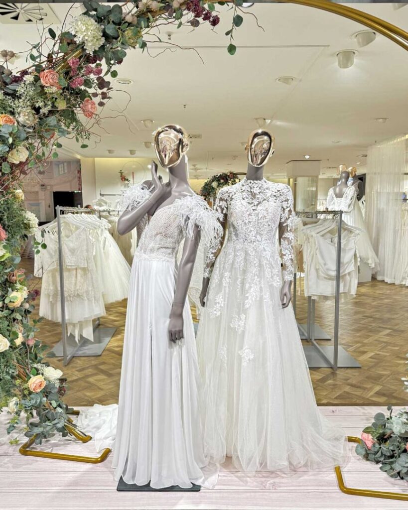 Zwei weibliche Figuren in Brautkleidern im Brautsalon