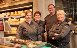 Vier Mitarbeiter hinter der Käse Theke