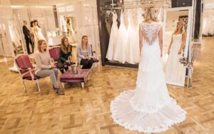 Frau im Brautkleid vor dem Siegel mit 3 Freundinnen die beraten