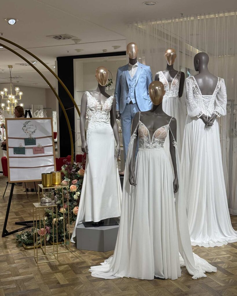 Mehrere Figuren in Brautmode im Eingang des Brautsalons