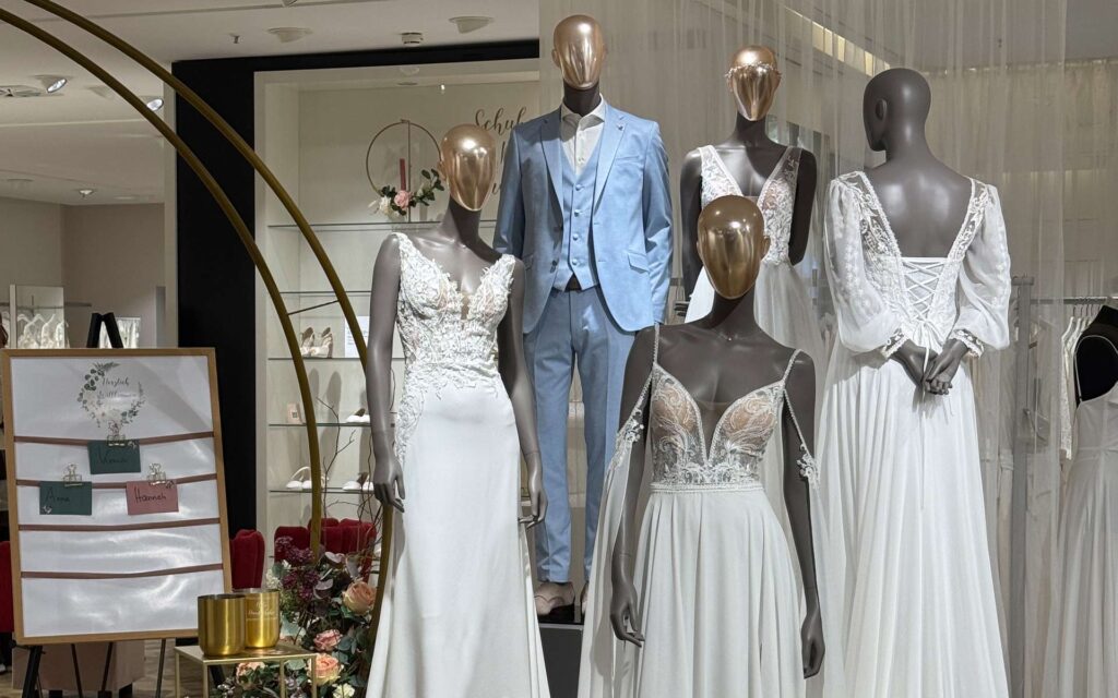 Mehrere Figuren in Brautmode im Eingang des Brautsalons