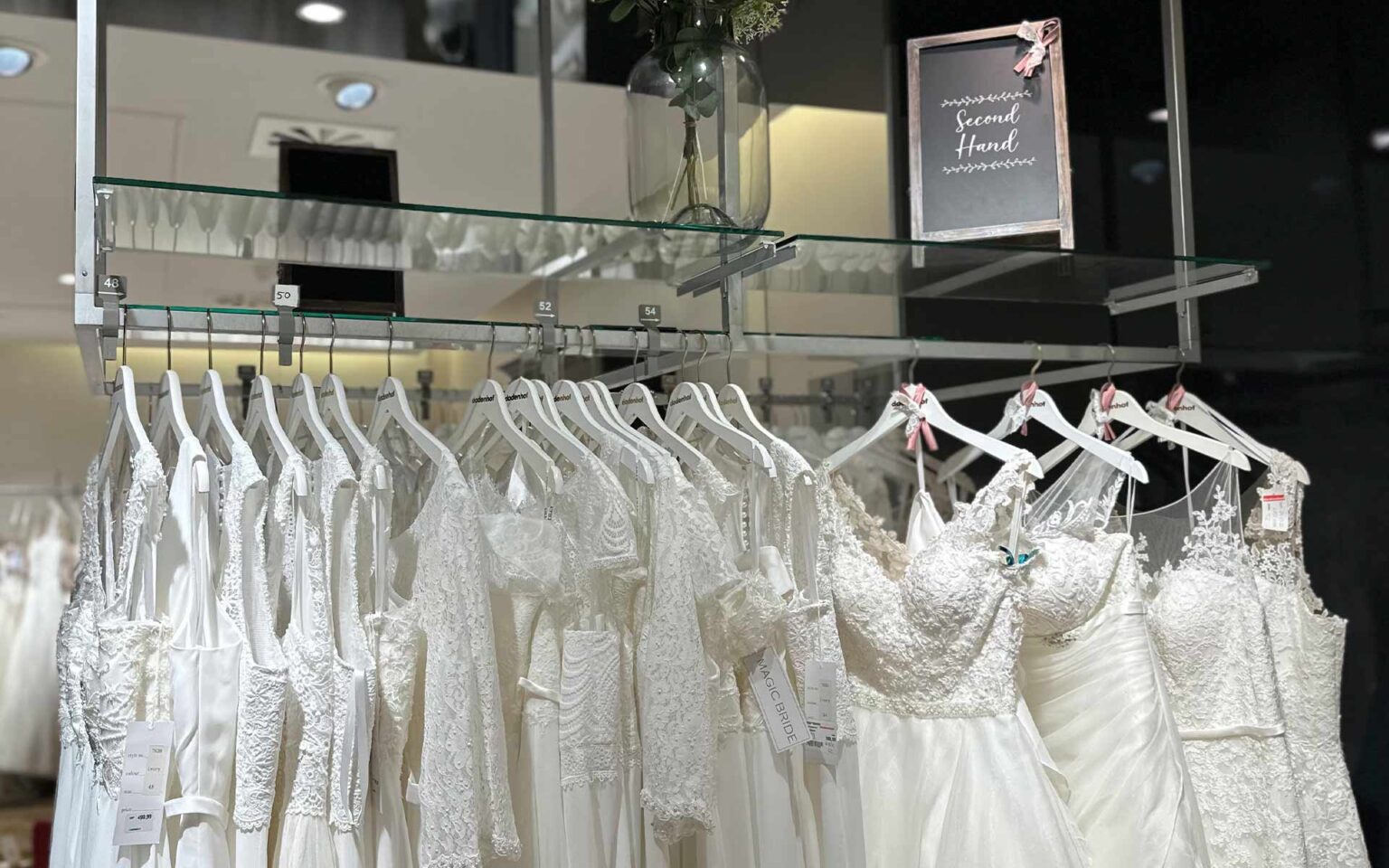 Second Hand Brautkleider an der Stange mit Schild