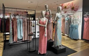 Drei Figuren mit glänzenden Abendkleidern in frohen Farben in der Abendmode