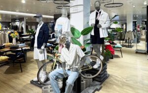 4 Herrenfiguren und 1 Fahrrad auf einer Werbefläche in der Herrenabteilung