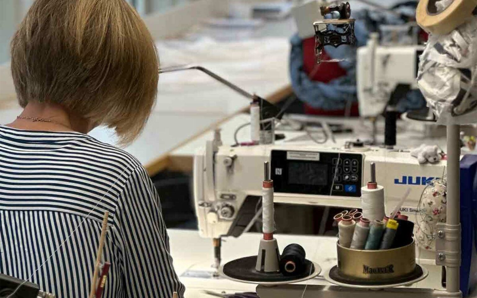 Schneiderin aus dem Änderungsatelier an der Nähmaschine