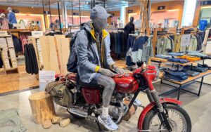 Figur sitzt in Outdoor Bekleidung auf einem Motorrad in der SportWelt