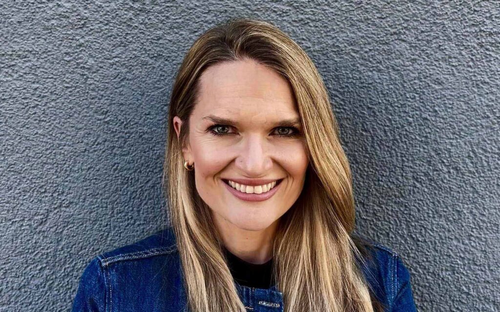 Frau mit langen Haaren vor grauer Wand