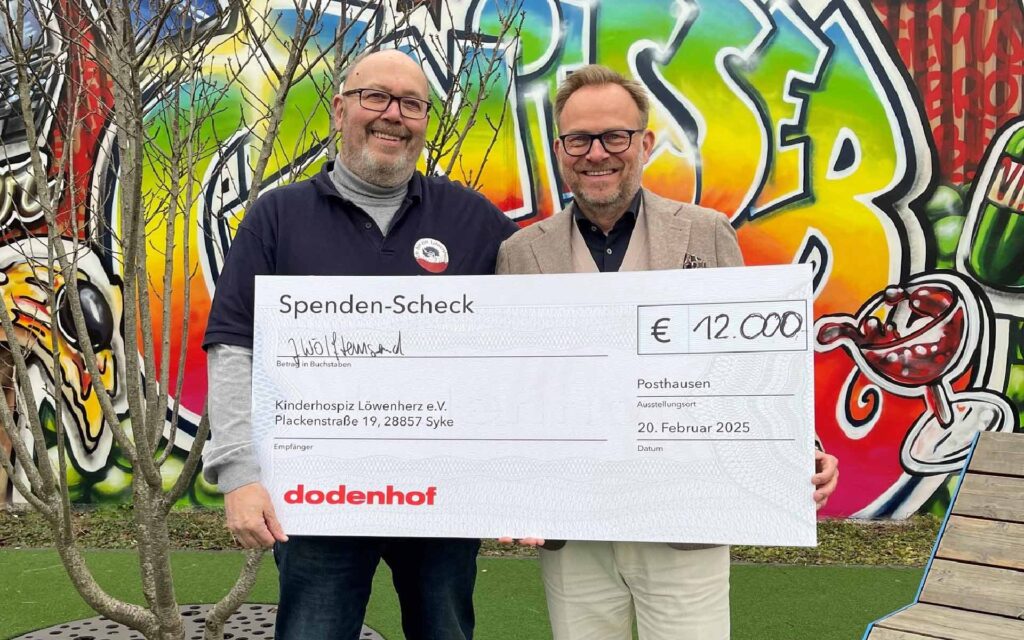 Zwei Personen mit einem Scheck über 12.000 Euro in der Hand
