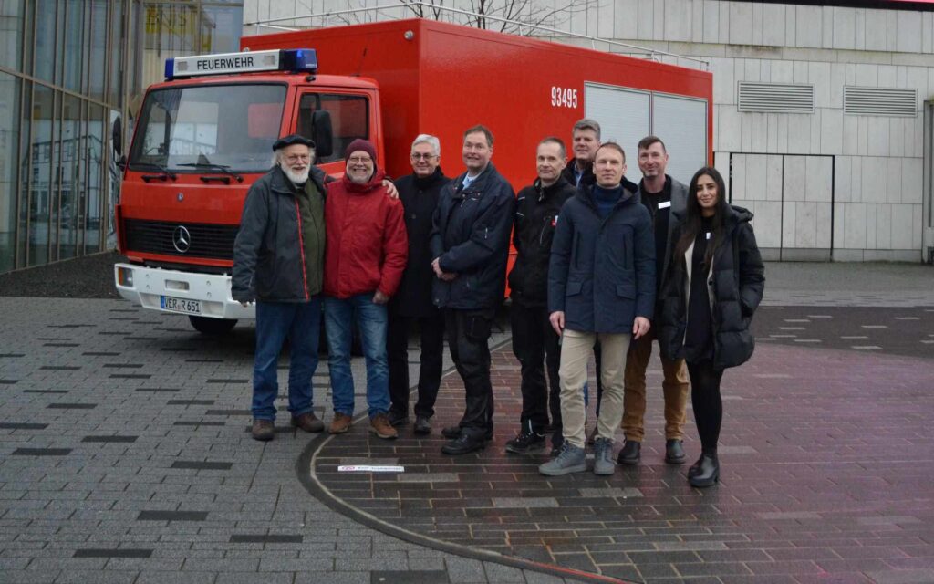 Mehrere Personen vor einem Feuerwehrfahrzeug