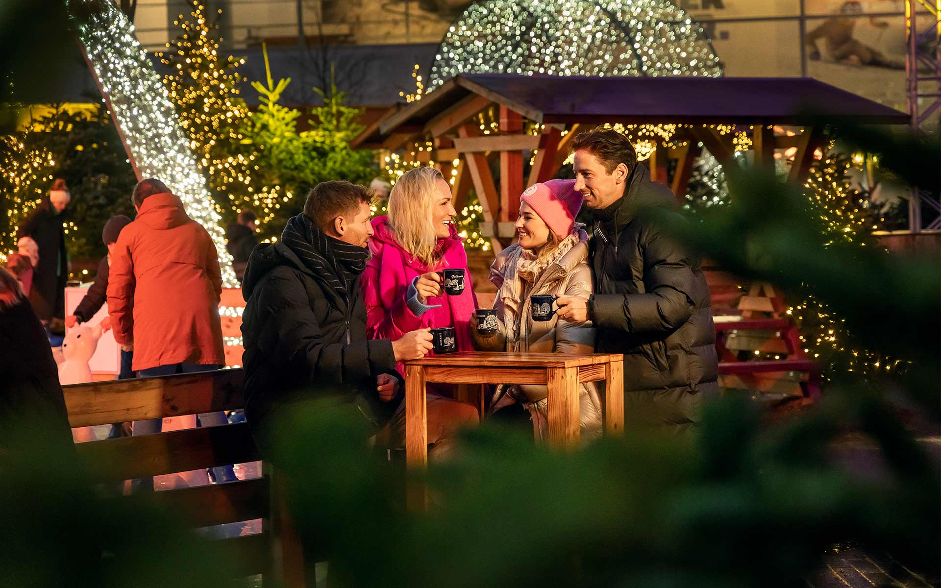 Zwei Frauen und zwei Männer beim Glühwein trinken