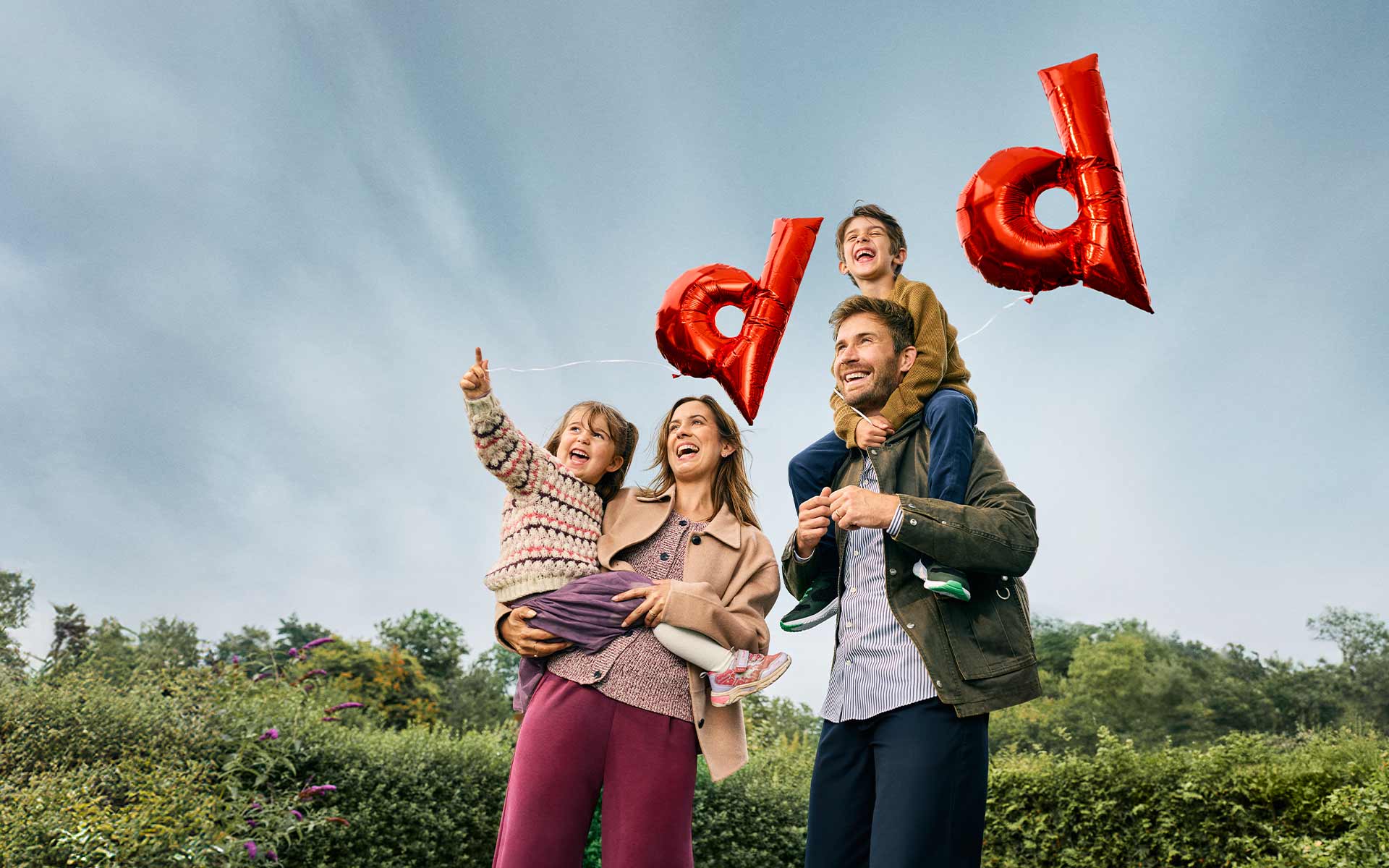Familie mit zwei roten d Luftballoons