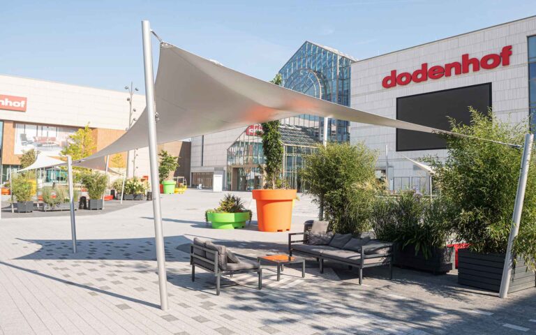 Vorplatz im Sommer mit Pflanzen und Sitzmöglichkeiten