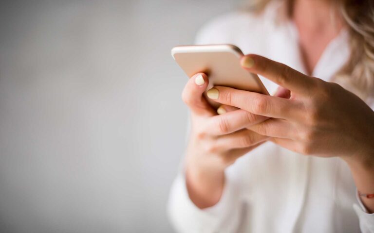 Eine Nahaufnahme wie eine Person ein Handy in der Hand hält